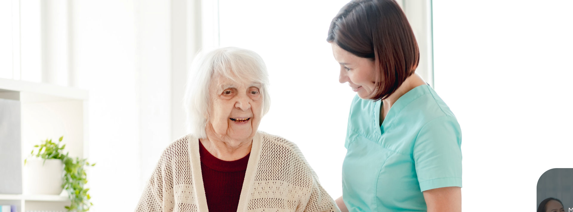 female aide talking to an elderly woman smiling